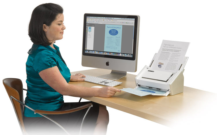 Woman sitting at computer and using printer